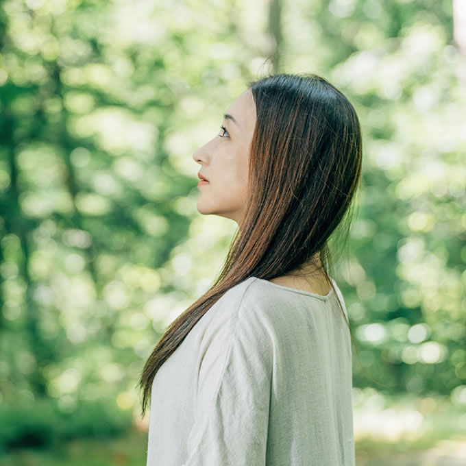 自然の中で上を向く女性